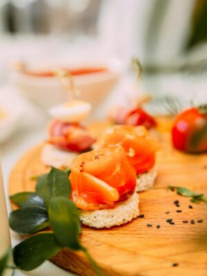 Served plate with portions of appetizers made of fresh bread and vegetable placed on banquet table