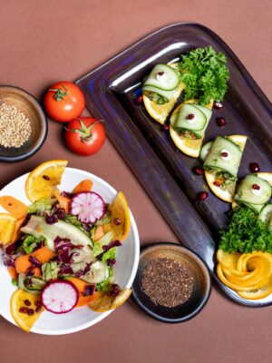Top view of a colorful vegetarian salad and appetizer platter with fresh vegetables and garnishes.